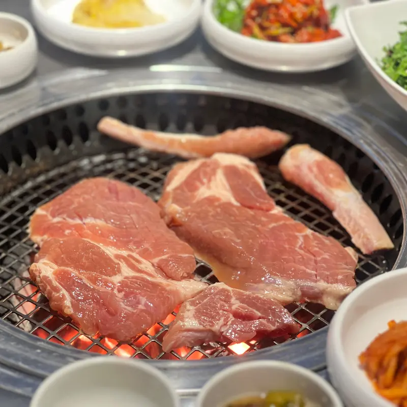 밑반찬과 고기가 함께 차려진 테이블