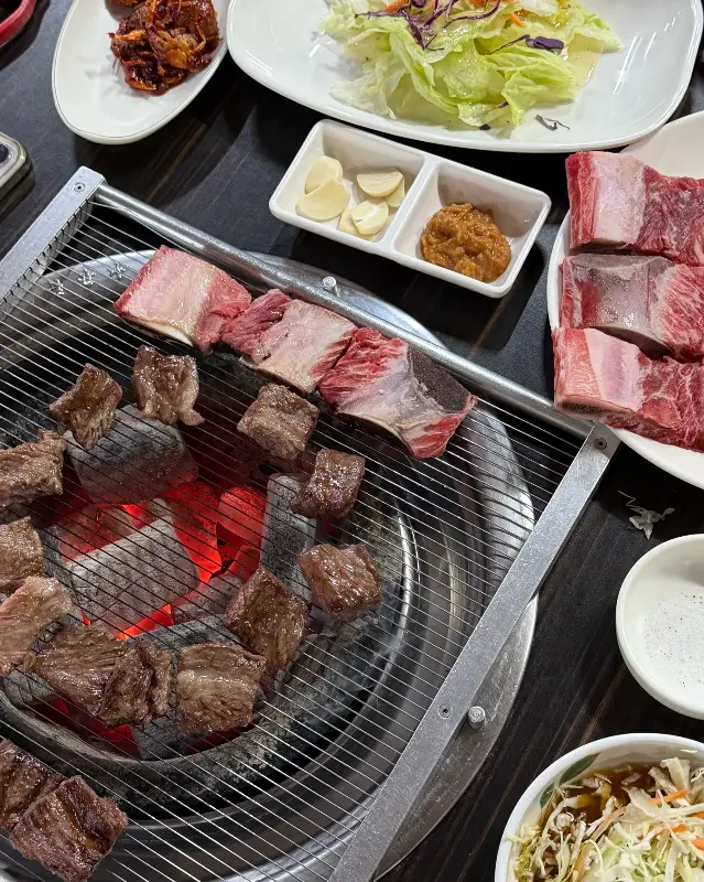 숯불 위에서 익어가는 갈비와 밑반찬