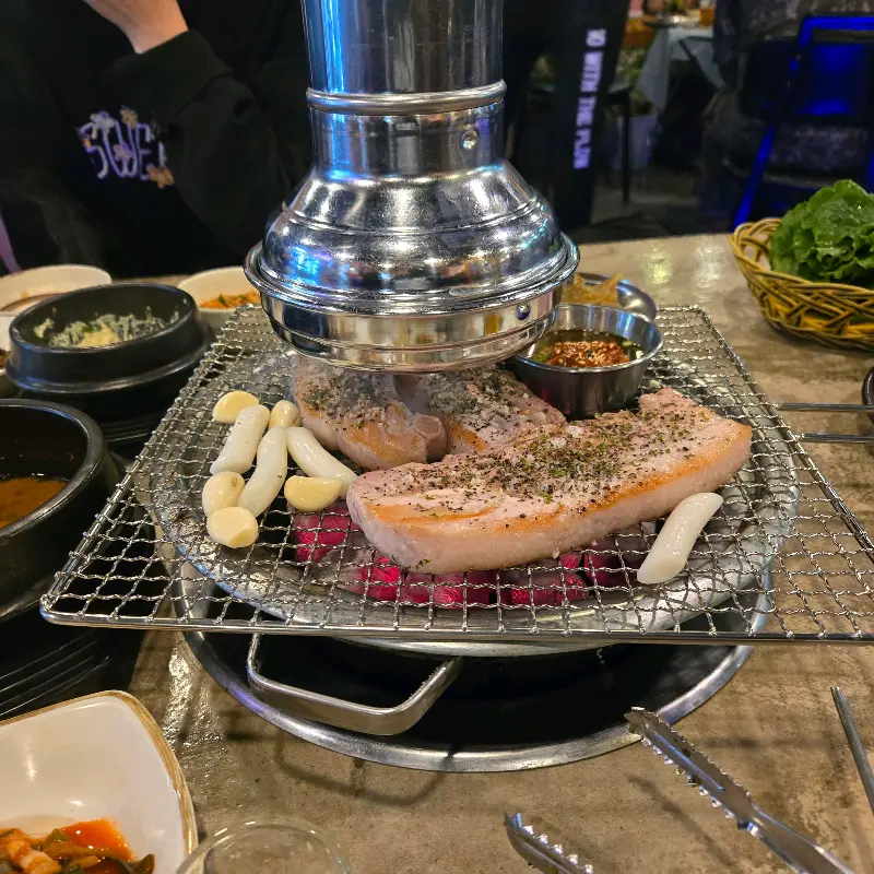 불판에 올려진 뽈살과 마늘, 떡