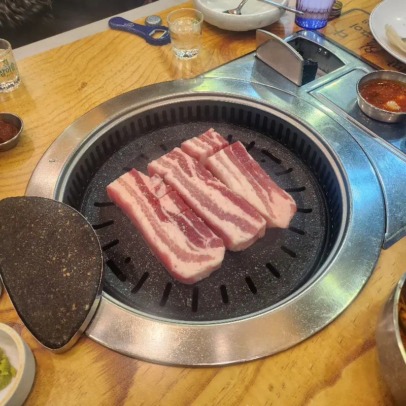 불판 위에 올려진 두툼한 숙성 삼겹살