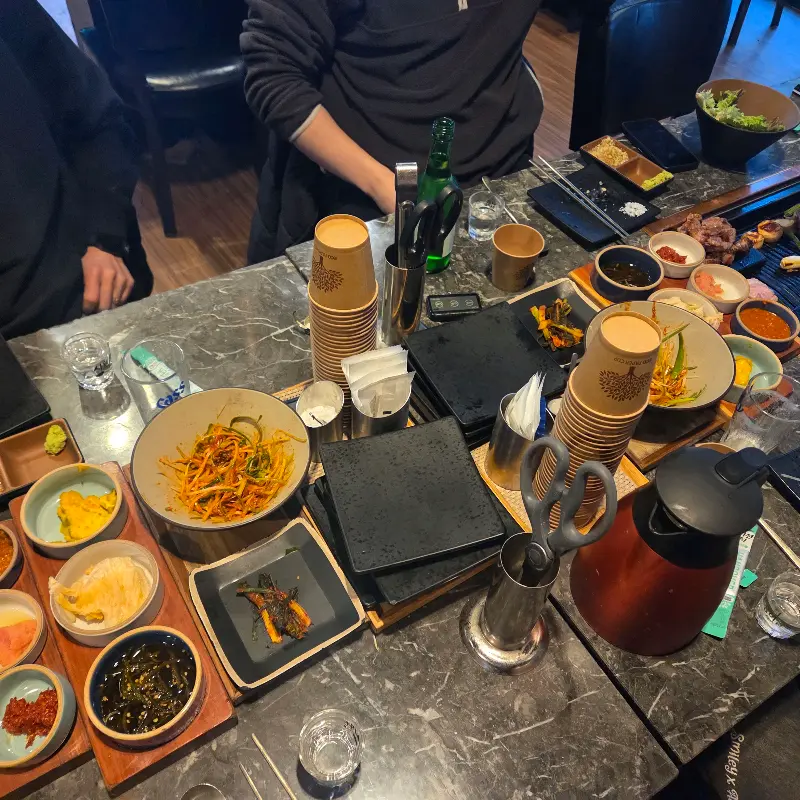 다양한 밑반찬과 소스가 정갈하게 차려진 테이블 전경