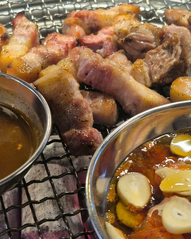 초벌된 삼겹살이 불판 위에서 지글거리고 있다.