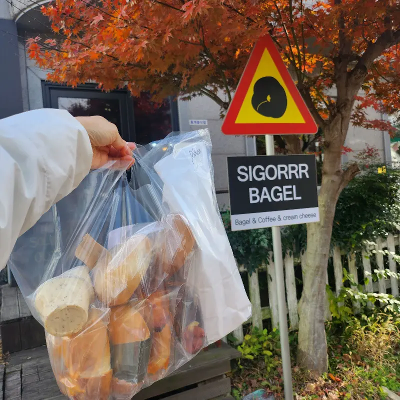포장된 베이글 봉투를 들고 있는 모습