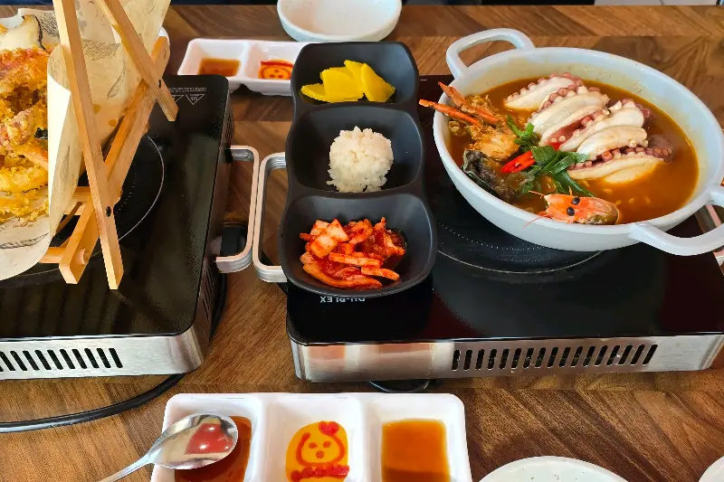 문어라면과 함께 제공되는 다양한 반찬들. 김치, 단무지, 밥까지 푸짐하게 즐길 수 있다.