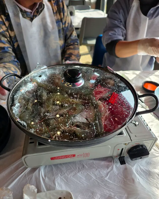 뚜껑이 덮인 냄비 안에서 익어가는 새우