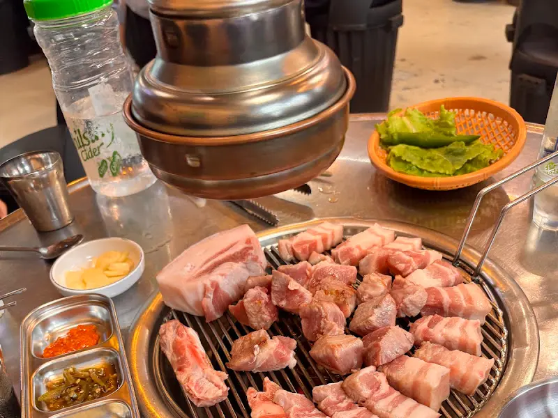 연탄불 앞에서 익어가는 흑돼지