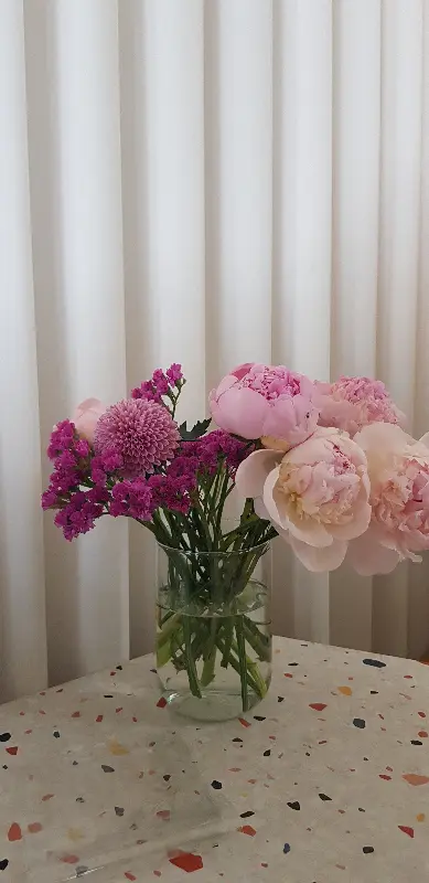 테이블 위에 놓인 꽃병. 싱그러운 꽃들이 공간에 생기를 불어넣는다.