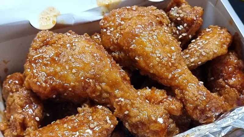 깨가 듬뿍 뿌려진 양념 치킨의 모습