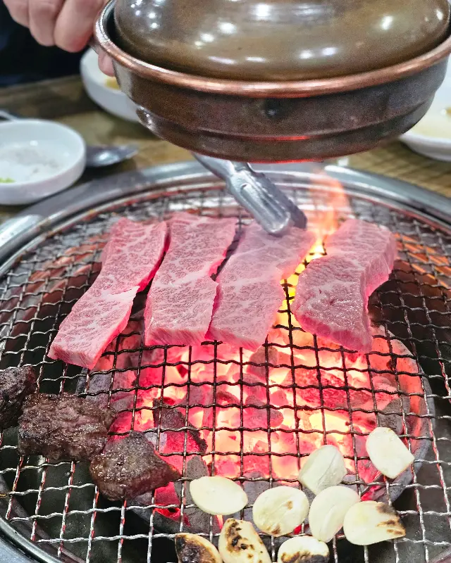 숯불 위에서 익어가는 등심과 마늘