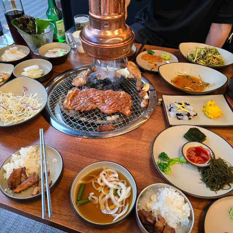 테이블 가득 차려진 반찬과 고기