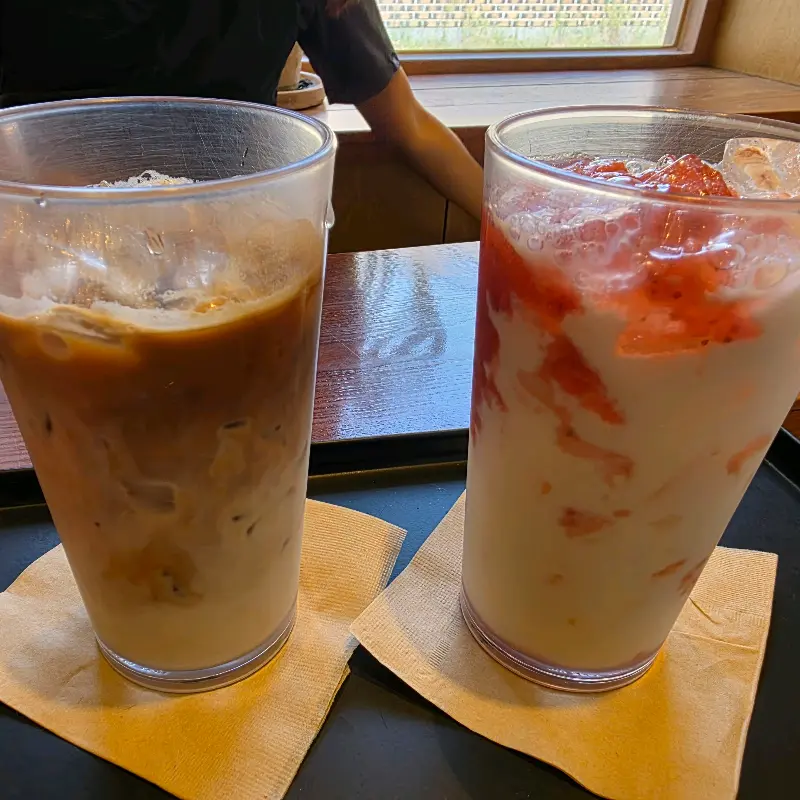 음료 두 잔이 놓여있는 모습. 하나는 딸기라떼, 하나는 라떼이다.