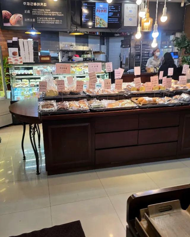 빵이 가득 진열된 매대와 분주한 직원들