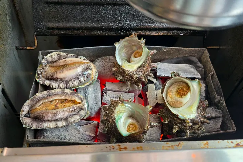 숯불 위에서 익어가는 전복과 뿔소라