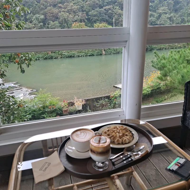 창가 테이블에 놓인 라떼와 빵