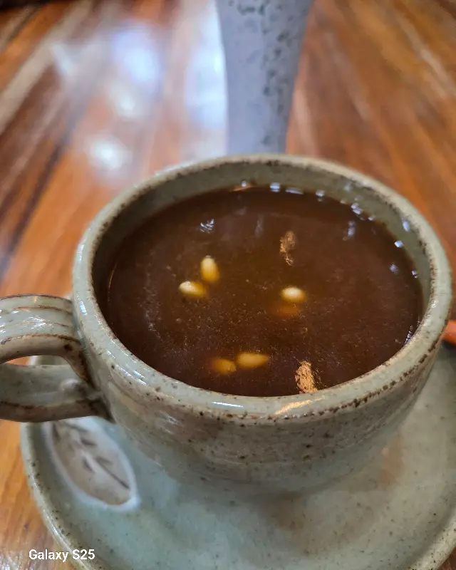 댜추차의 모습. 도자기 찻잔에 담겨 있으며, 찻물 위에는 잣이 몇 알 띄워져 있다.