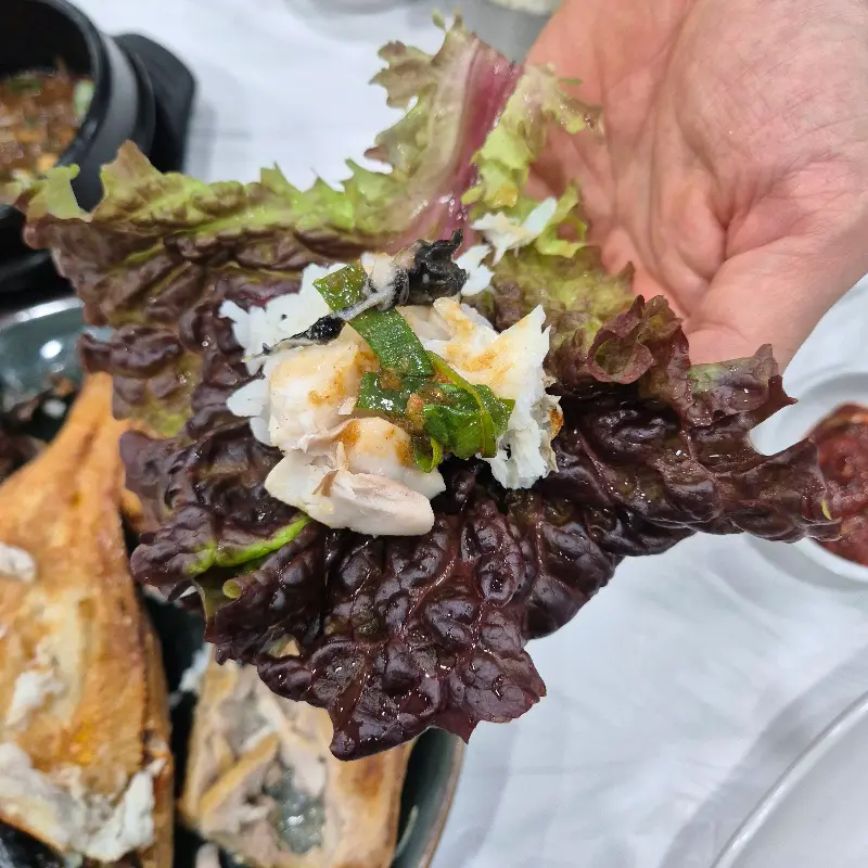 쌈 채소에 생선구이를 올려 한 입