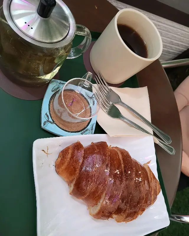 따뜻한 차와 크로와상이 함께 놓여있는 테이블 모습