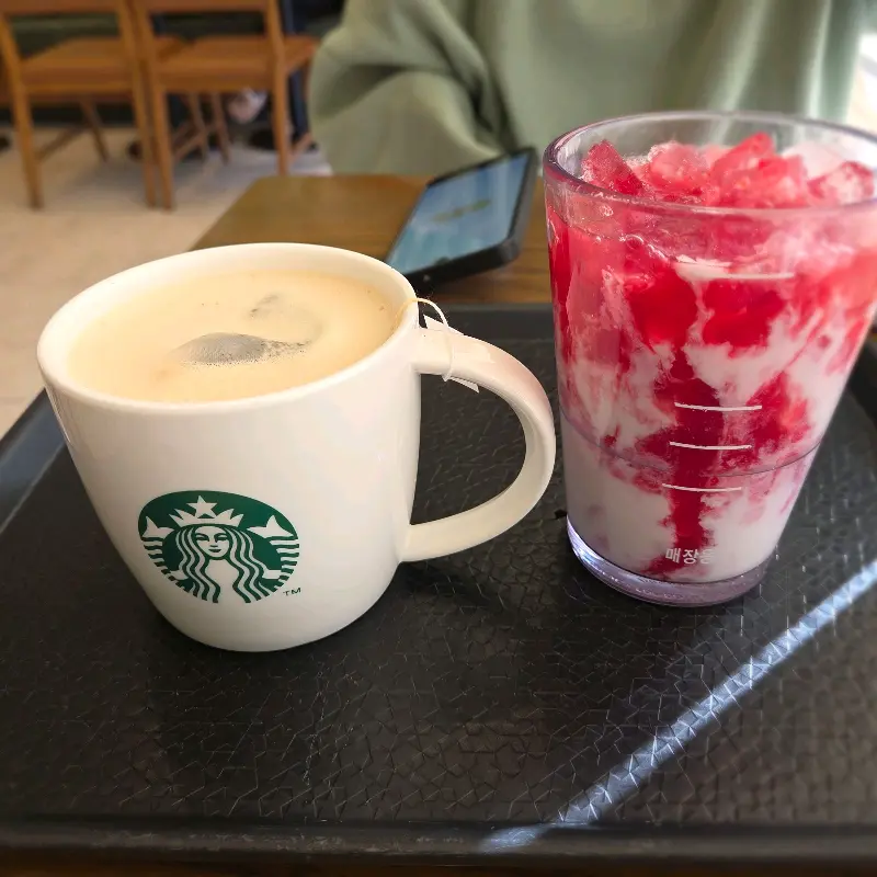 테이블 위에 놓인 스타벅스 컵 두 잔
