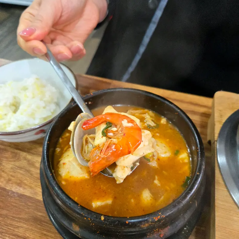 숟가락 위에 올려진 해물과 순두부