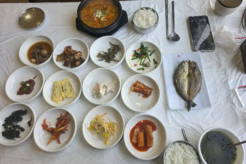 굴비 백반 한 상 차림. 다양한 밑반찬과 굴비, 애호박찌개가 푸짐하게 차려져 있다.