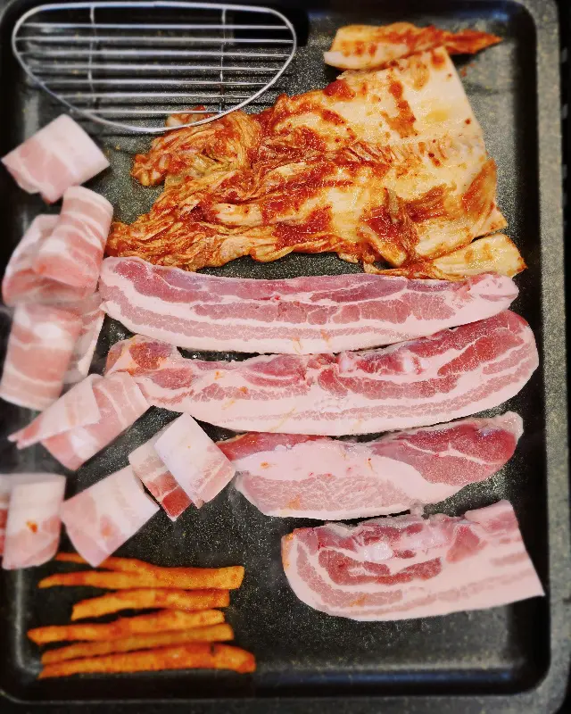 불판 가득 구워진 삼겹살과 김치