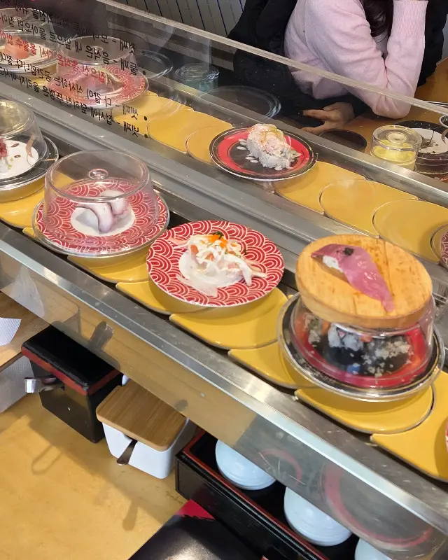 쉴 새 없이 돌아가는 레일 위의 초밥들