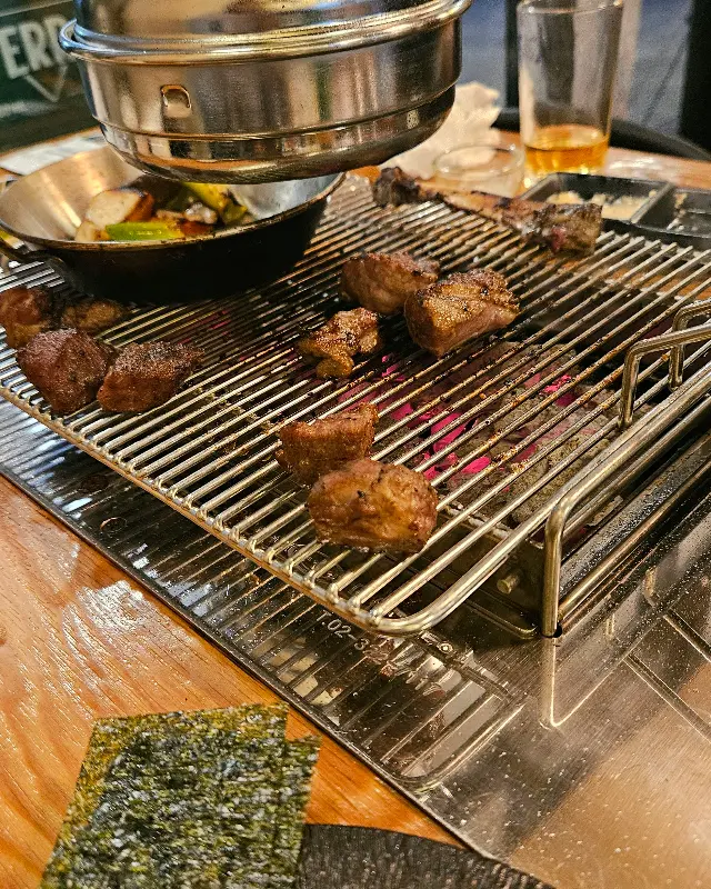 숯불 위에서 맛있게 구워지는 양갈비와 채소