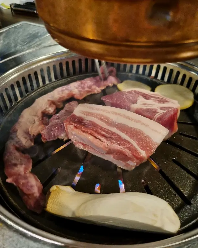 삼겹살과 버섯이 함께 구워지는 모습
