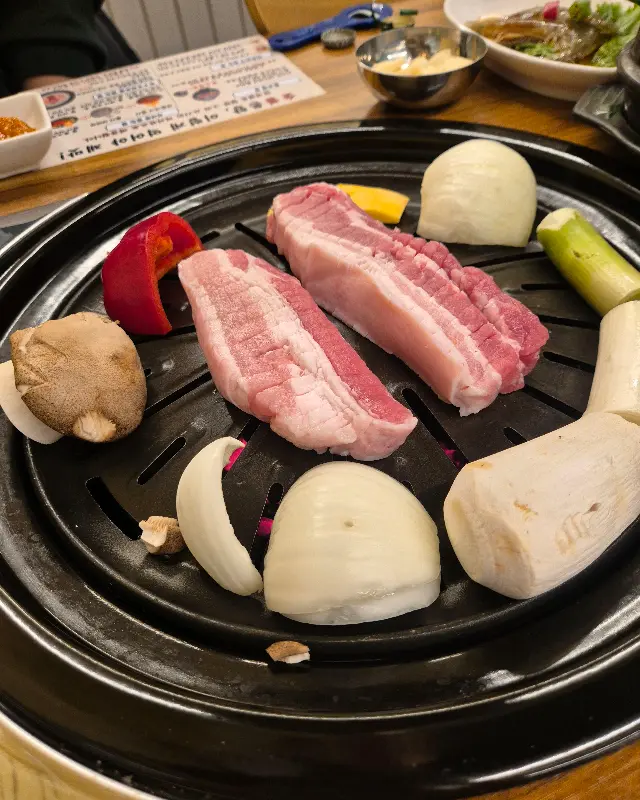 숯불 위에 올려진 삼겹살과 버섯, 양파