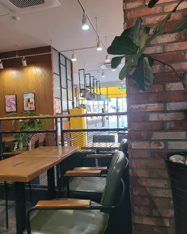 메가커피 내부 인테리어 사진. 벽돌 벽과 은은한 조명이 아늑한 분위기를 연출한다.