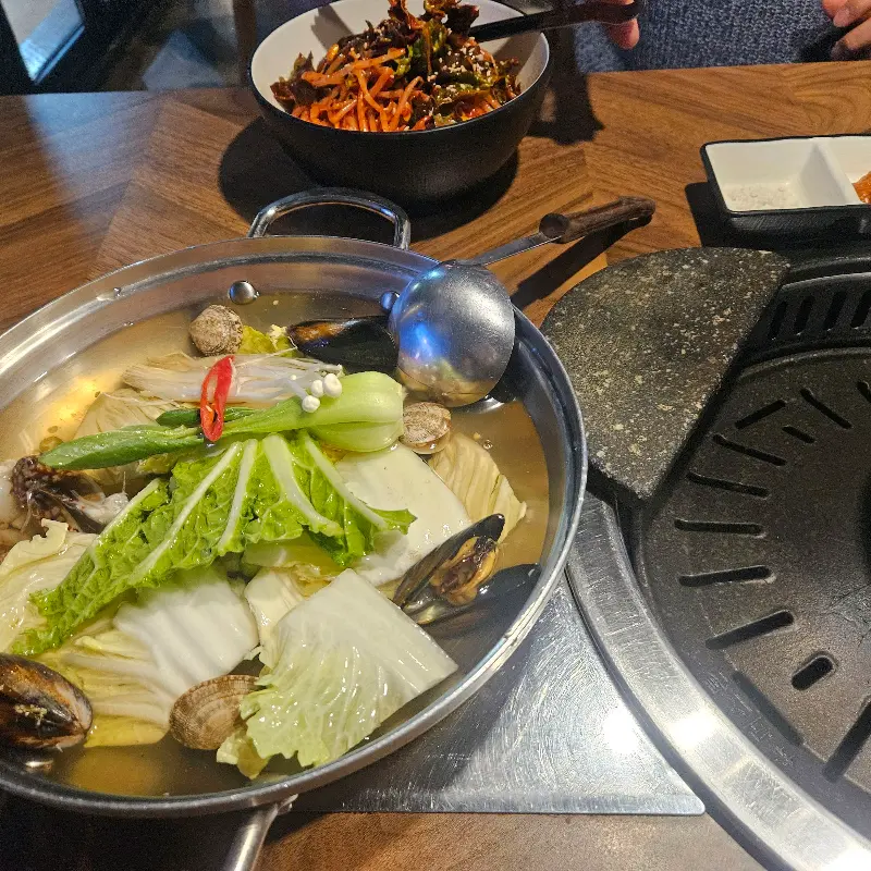 식탁 위에 놓인 삼겹살과 조개탕