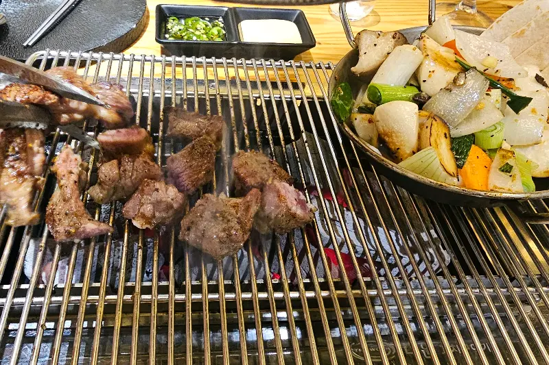 잘 구워진 양갈비와 곁들임 채소가 담긴 접시