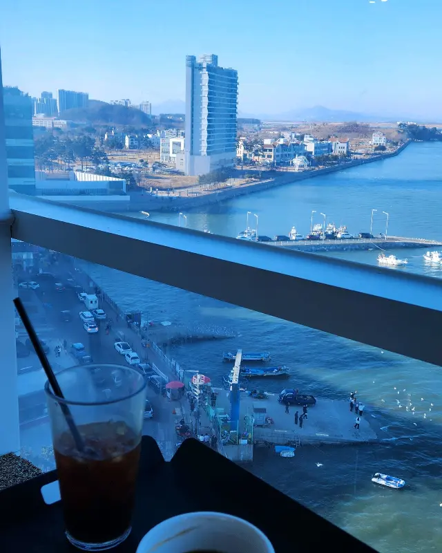 바다를 배경으로 놓여진 커피와 음료