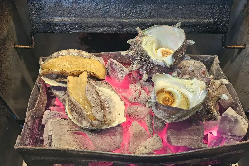 숯불 위에서 익어가는 전복과 뿔소라