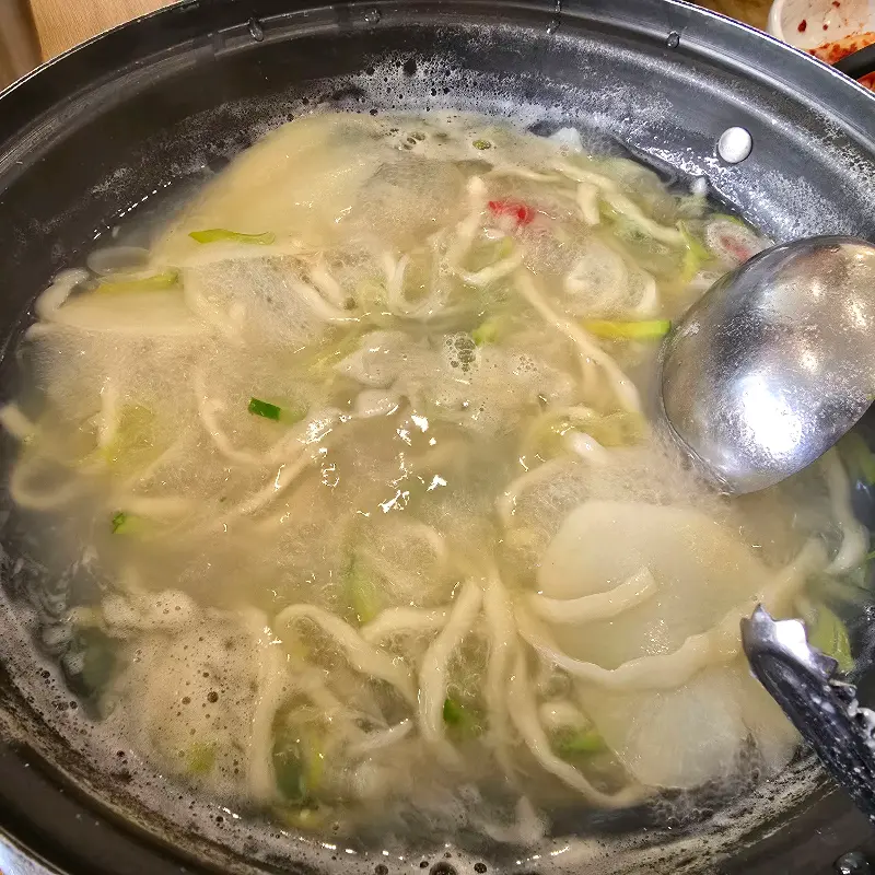 칼국수를 덜어먹을 수 있게 국자와 집게가 준비되어 있다