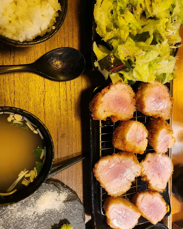 카츠와 곁들임 메뉴들이 조화롭게 담겨있는 모습