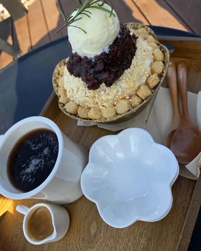 야외 테이블에 놓인 흑임자 빙수와 커피