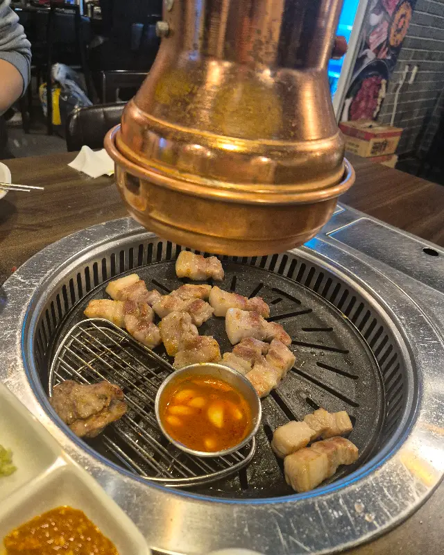 잘 구워진 삼겹살이 불판 위에 올려져 있는 모습