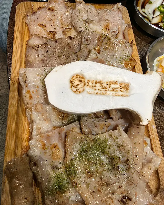 막창과 삼겹살이 담긴 나무 도마