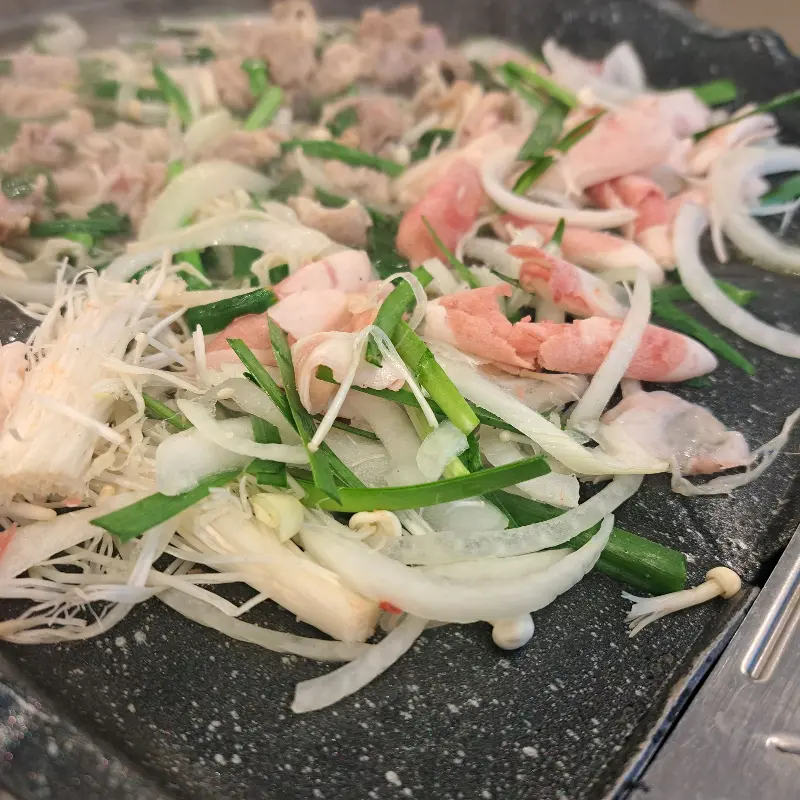 불판 위에서 구워지는 오리 차돌박이와 채소