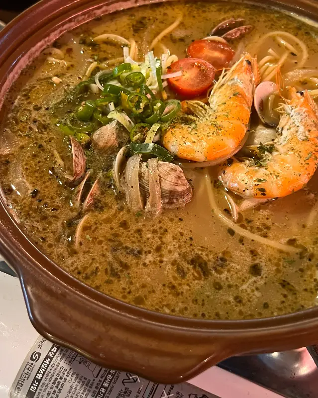 새우, 조개, 토마토 등이 들어간 탕 요리 사진