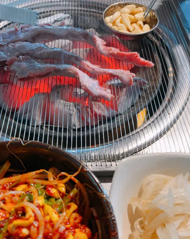 숯불 위에서 익어가는 갈매기살과 마늘