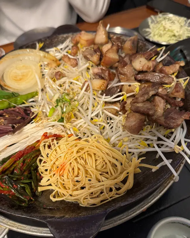 철판 위에 가득 담긴 꼬들살과 채소의 조화