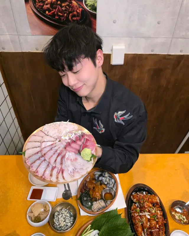 맛있는 회를 들고 미소짓는 손님: 회의 신선함과 푸짐함을 보여주는 사진으로, 즐거운 식사 분위기를 엿볼 수 있다.