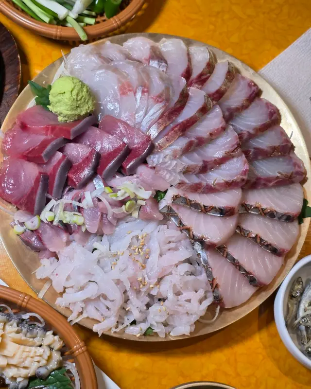 제철 모듬 잡어회: 다양한 종류의 회가 푸짐하게 담겨 있으며, 특히 껍질이 붙어 있는 회는 신선함이 느껴진다.