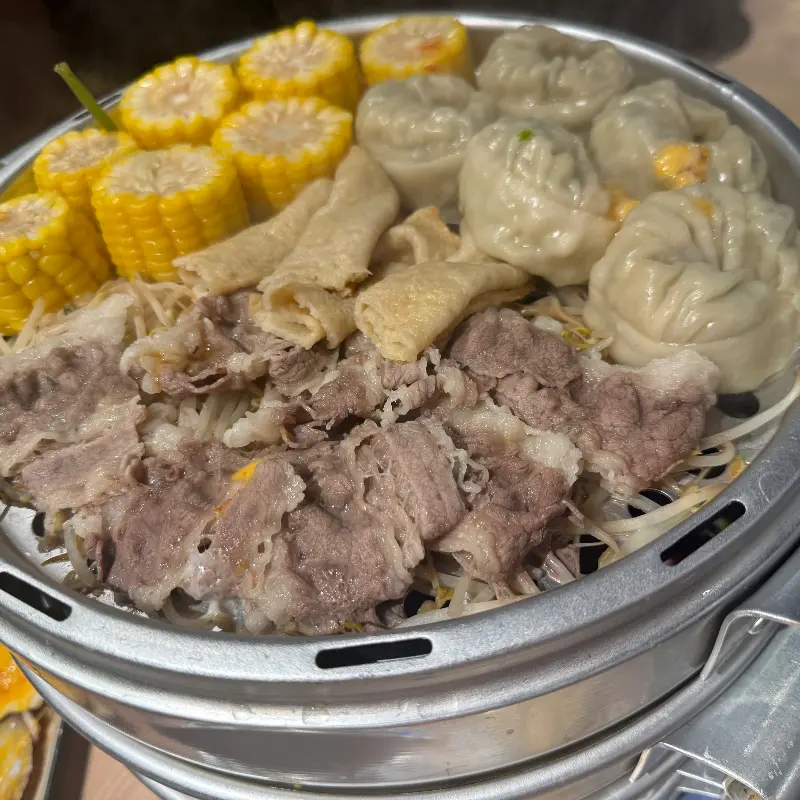 고기, 옥수수, 만두가 담긴 찜기