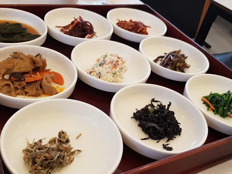 다양한 반찬들이 나무 쟁반 위에 담겨 있는 모습