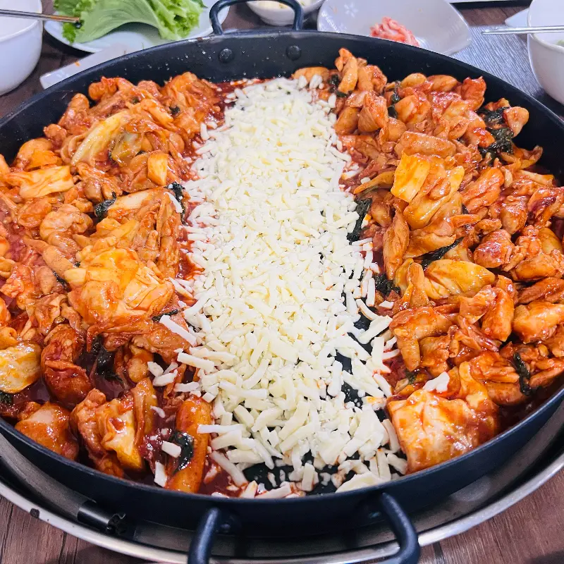 닭갈비 위에 치즈가 듬뿍 뿌려진 모습