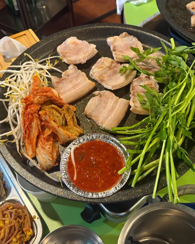 삼겹살, 김치, 콩나물, 미나리를 한 불판에