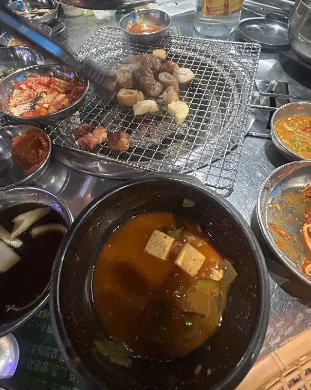 테이블 가득 차려진 음식들, 된장찌개도 보인다.